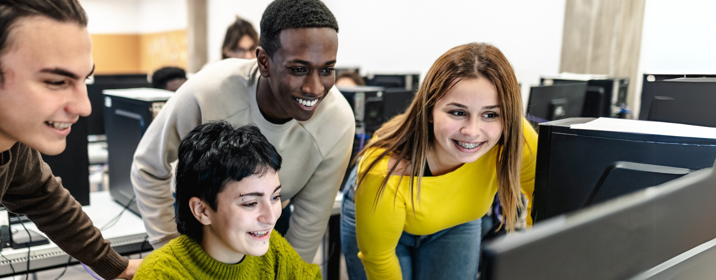 high school students looking at a computer